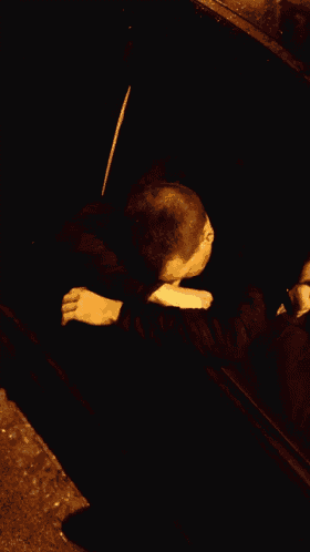 a man giving the middle finger while leaning on a car