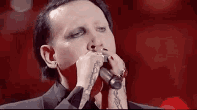 a close up of a man singing into a microphone .