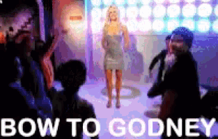 a woman in a dress is standing in front of a crowd with the words bow to godney written on the bottom