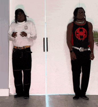 two men standing next to each other one wearing a spider man tank top