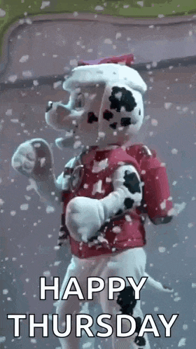 marshall from paw patrol is standing in the snow with snow falling around him .