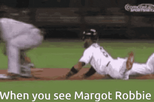 a baseball player is sliding into home plate while a catcher watches .