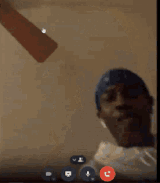 a man is smoking a cigarette on a video call while wearing a headband .