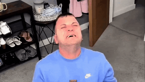 a man wearing a blue nike sweater is making a funny face