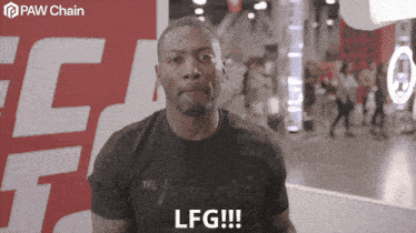 a man in a black shirt says lfg in front of a paw chain sign
