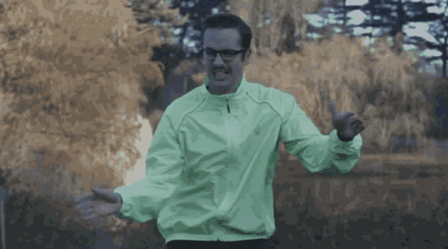 a man wearing glasses and a neon green jacket is dancing