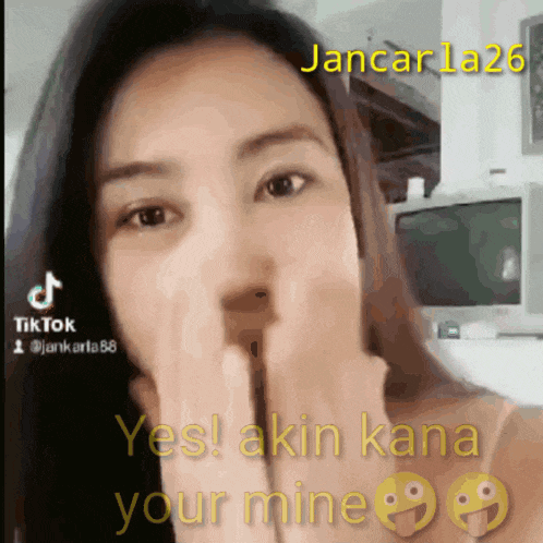 a woman is covering her mouth with her hands and the words yes akin kana your mine are above her
