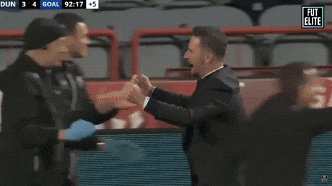 two men hugging in front of a screen that says fut elite on it
