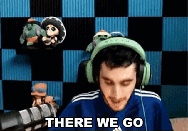 a man wearing headphones and a blue shirt says there we go