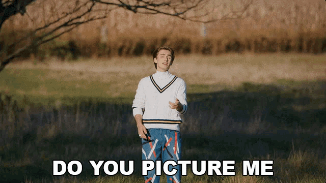 a man in a white sweater stands in a field with the words do you picture me below him