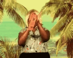 a woman covering her face with her hands in front of palm trees on a beach