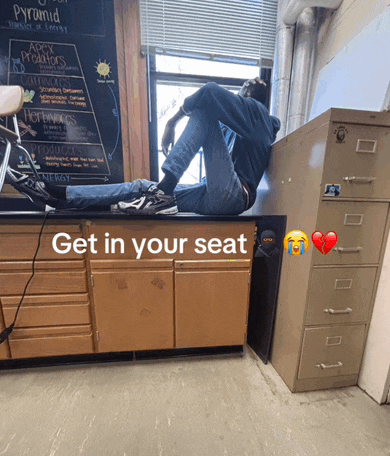 a man sits on a counter with the words get in your seat written on the bottom