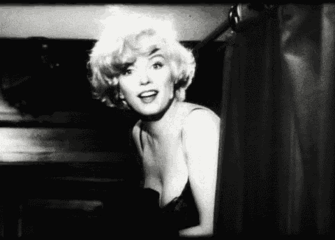 a black and white photo of marilyn monroe in a black dress .