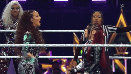 a woman with red hair is standing in a wrestling ring with a referee