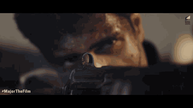 a close up of a man holding a gun with the hashtag majorthefilm