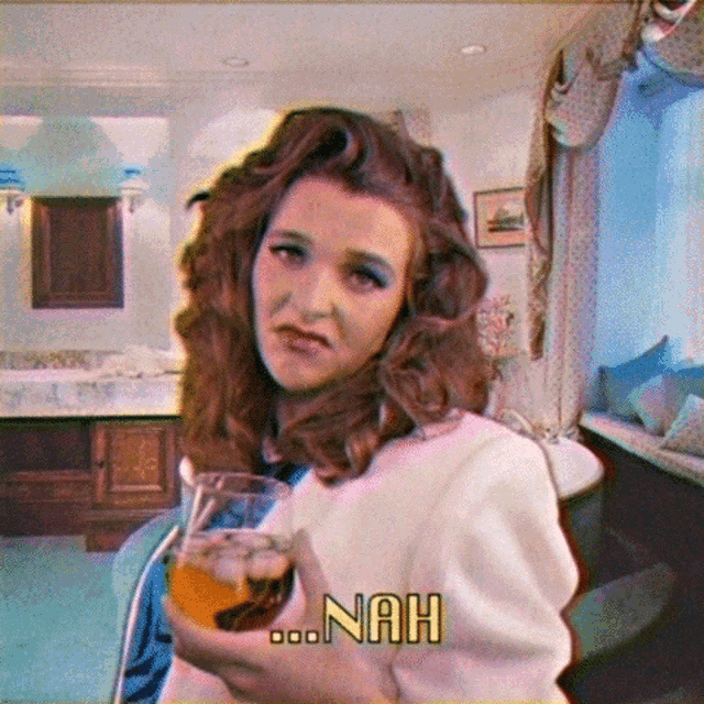 a woman holding a glass of beer with nah written on the bottom