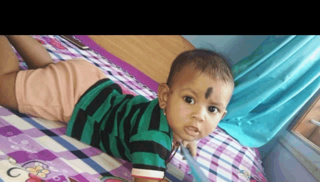 a baby is laying on his stomach on a bed