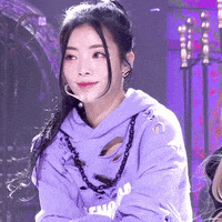 a woman is wearing a purple hoodie and a purple necklace .