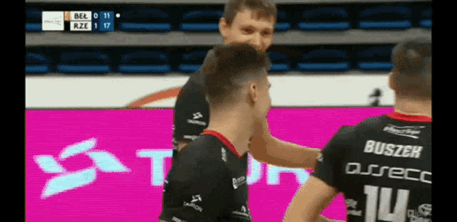 a man wearing a jersey with the number 14 on it is talking to another man