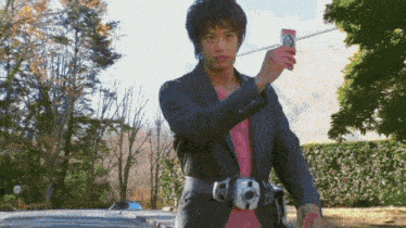 a man in a suit and pink shirt is holding a card that says ' a ' on it
