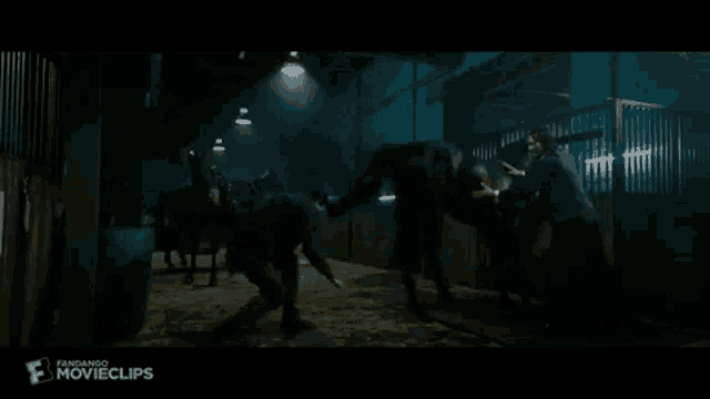 a group of horses are standing in a dark stable with the word movieclips on the bottom right