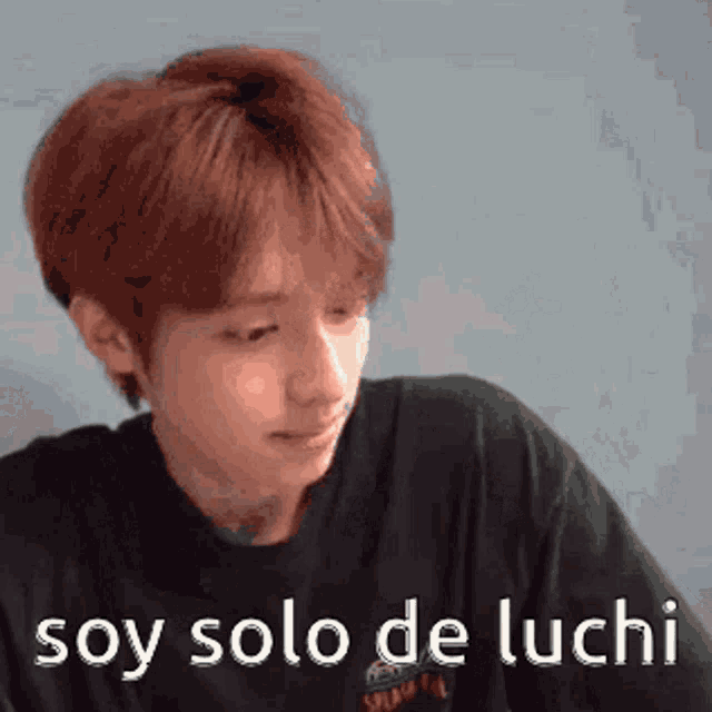 a young man with red hair is wearing a black shirt and says soy solo de luchi