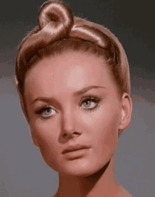 a close up of a woman with a bun in her hair .