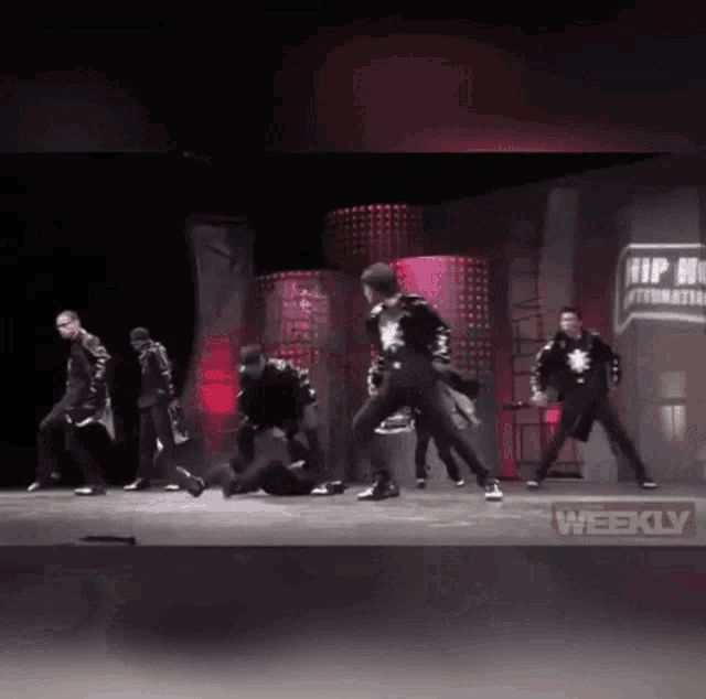 a group of men are dancing on a stage with a sign that says hip hop international