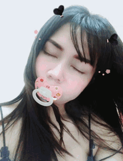 a woman with a pacifier in her mouth and hearts on her head