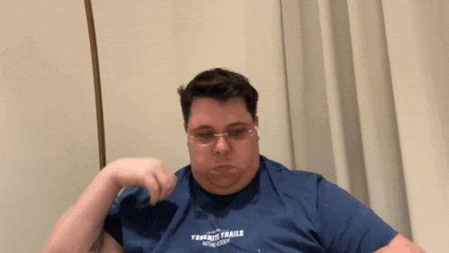 a man wearing glasses and a blue shirt that says " physical ability " on it