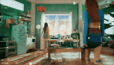 a woman in a blue top is standing in a living room with a recorder