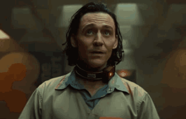 a man with a collar around his neck is making a face .