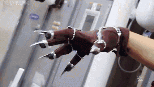a close up of a person 's hand wearing a clawed glove .