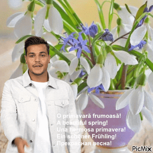 a man in a white jacket stands in front of a vase of flowers with a caption that says a beautiful spring