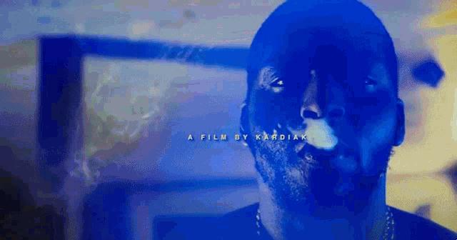 a close up of a man smoking a cigarette with the words a film by kardiak above him