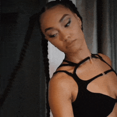 a woman in a braided ponytail is wearing a black top