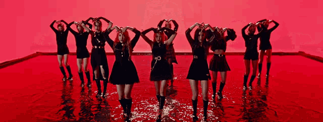 a group of women are dancing in a pool of red liquid