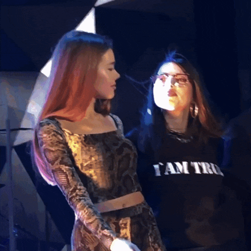 two women are standing next to each other one is wearing a shirt that says i am tru