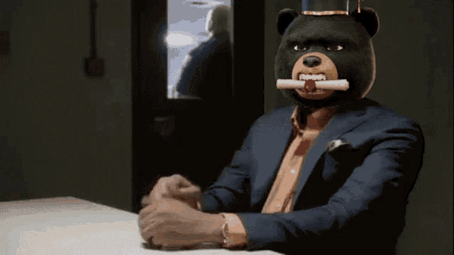 a man in a suit and top hat with a teddy bear mask on his face