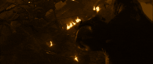 a group of people are standing around a fire