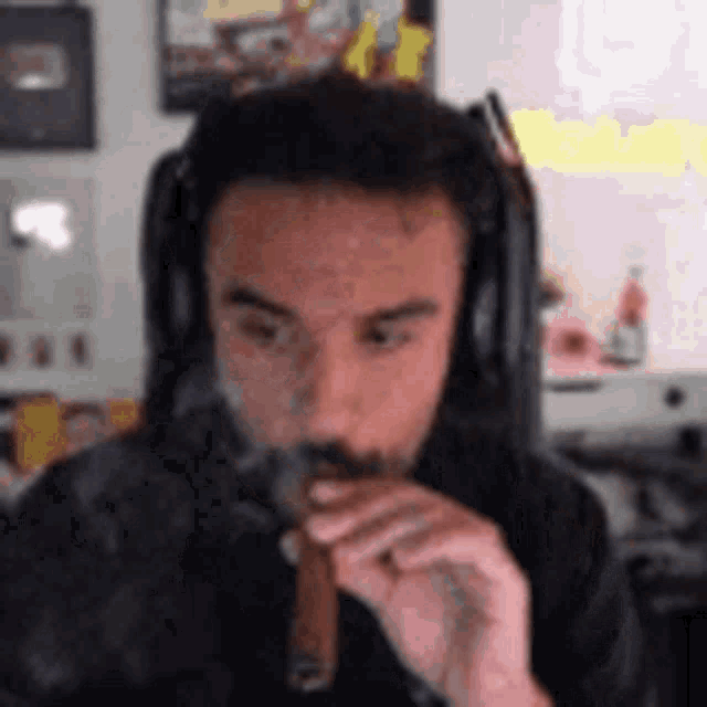 a man with headphones is smoking a cigar .