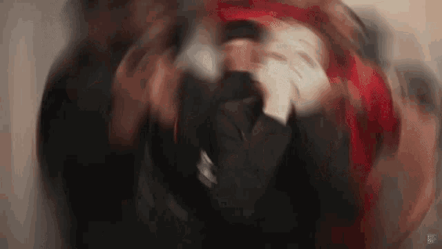 a blurry image of a person with red hair holding a microphone