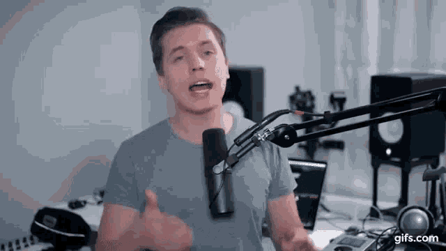 a young man is standing in front of a microphone in a studio .