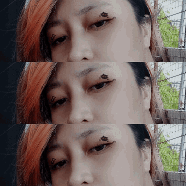 a woman with red hair has a tattoo on her eye