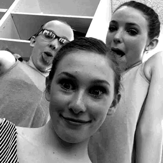 three girls are posing for a picture with one wearing sunglasses and the other wearing a tank top