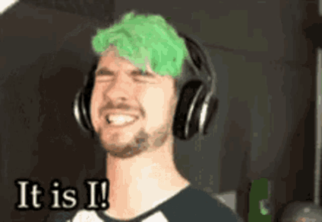 a man with green hair is wearing headphones and says it is i!
