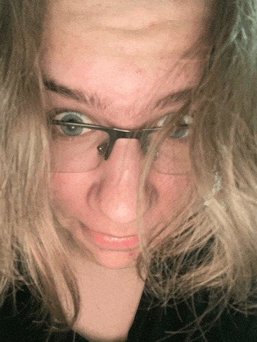 a close up of a person wearing glasses and making a face