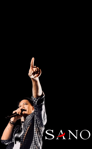 a man singing into a microphone with the word sano in the corner