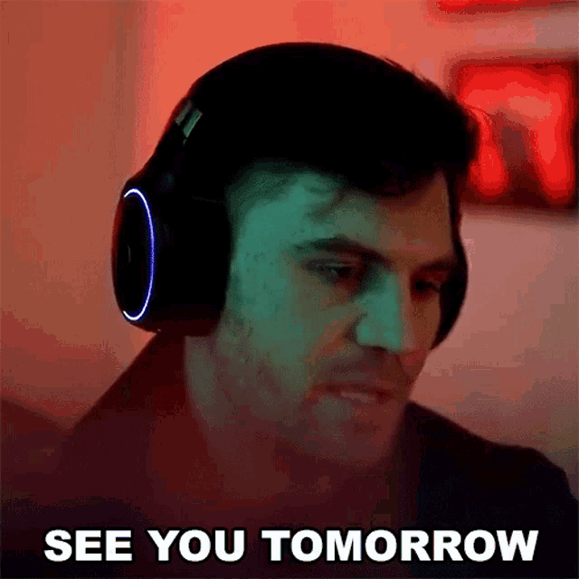 a man wearing headphones says `` see you tomorrow '' while looking at his computer screen .