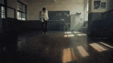 a person standing in a dark room with a poster on the wall that says ' a '